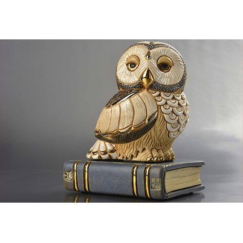 Hand‑carved ivory owl sculpture perched on book with gold accents, artisanal collectible for bookshelf or study décor. Hand‑painted in Uruguay with gold accents. A refined décor piece for scholars, libraries, desks. Scholarly Desk Decor.